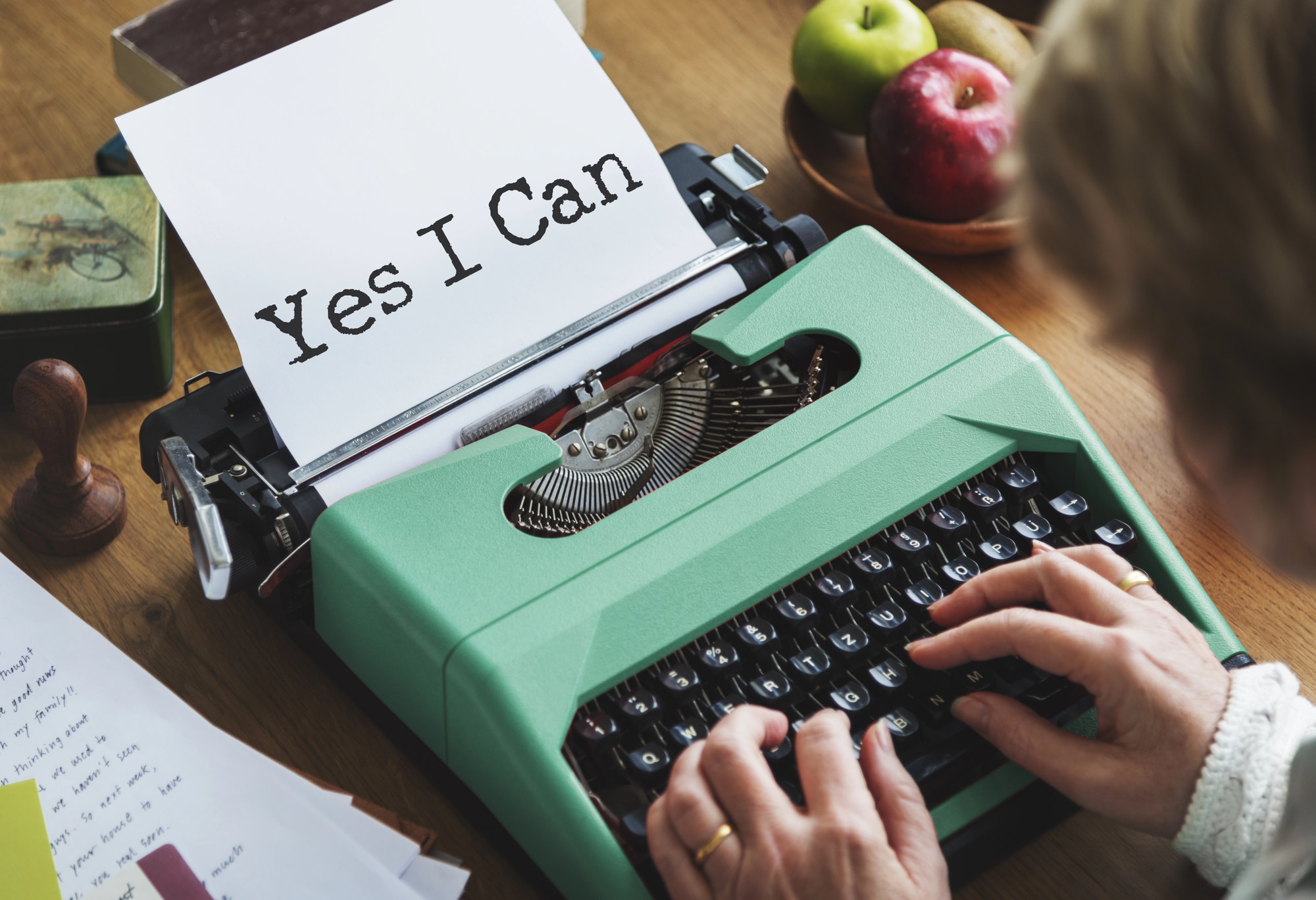 Self Publishing Authority: Someone types “Yes, I can” on a green typewriter on their desk.
